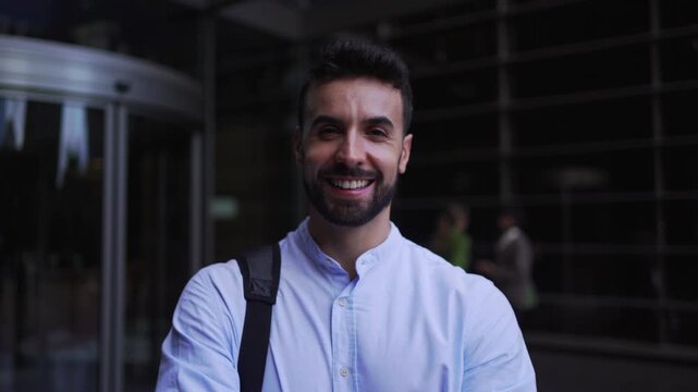 Portrait of a young businessman with arms crossed looking at the camera smiling.