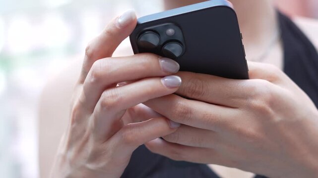 woman holds smart phone in her hands and scrolls through the news feed. Close up of hand uses mobile. point finger on screen, texting text message.	