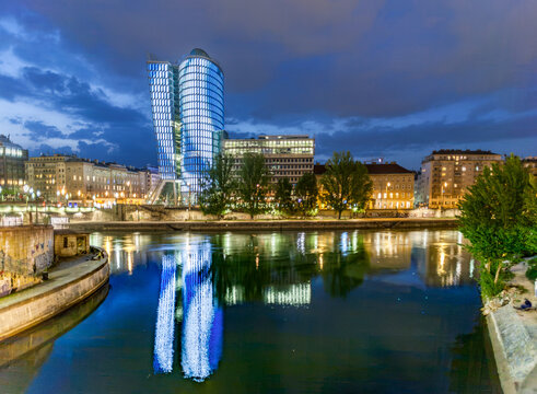 reflection of Uniqa tower in Vienna by night in river Danube. The building received the European Union Green Building label as first building in Austria