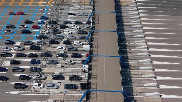 Drone view of the A1 motorway toll plaza in Melegnano, capturing the geometric layout of toll lanes and surrounding road infrastructure near Milan.