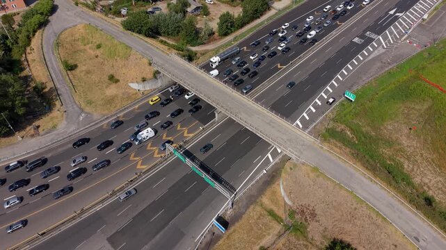 Aerial view of heavy summer traffic on the A1 motorway near Milan, showing long lines of vehicles and congestion on one of Italy's major transport routes.