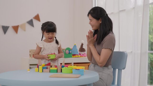 Mother Daughter Child Family Playing Colorful Wooden Block Toy Home Birthday Celebration, Creative Learning Activity, Joyful Togetherness, Bright Window, Festive Bunting, Imaginative Kitchen Play