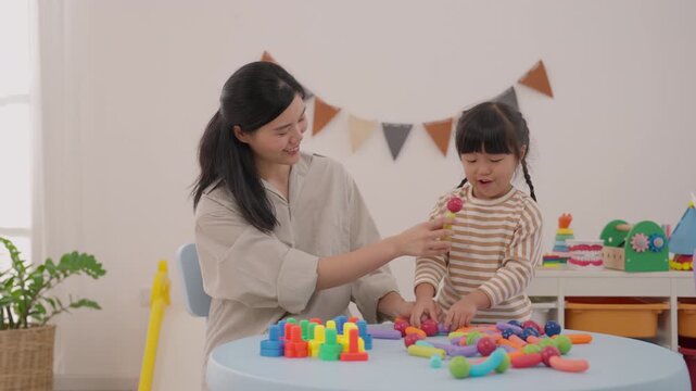 Mother Daughter Child Family Playing Colorful Toy Block Creative Activity at Home, Joyful Learning, Imagination, Family Bonding, Bright Room, Playful Decorations, Indoor Plants, Cheerful Table Fun