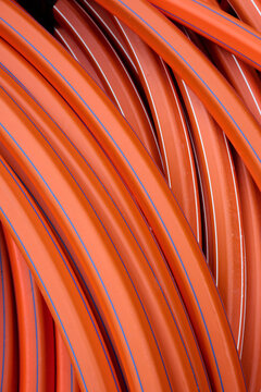 Close-up of an orange flexible plastic pipe used in public works.