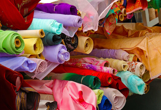 Colorful fashion textile materials in rolls on street market
