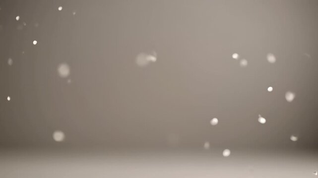 ?Gentle falling snowflakes against a soft gray background