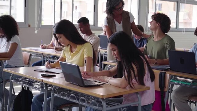 High school teacher helping student during exam in classroom. Footage with copy space.