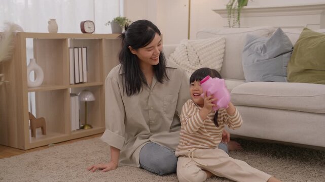 Mother and child playing with pink toy in cozy living room, sharing warm family moment together on soft rug with joyful family bonding at home