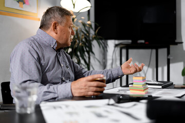 Fototapeta premium Businessman discussing ideas in a modern office setting with sticky notes and documents on the table during a productive meeting
