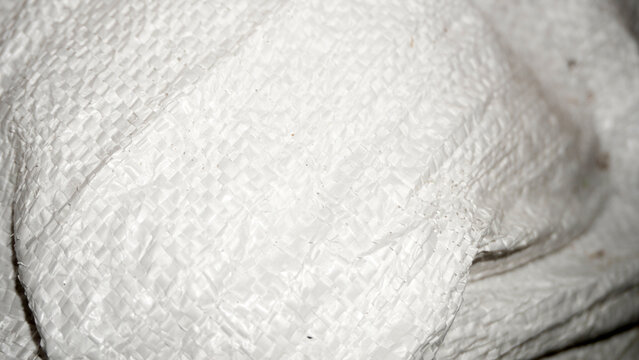 White woven polypropylene sack texture with crosshatch pattern.