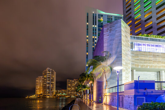 Miami Riverwalk at night with palm trees and skyscrapers