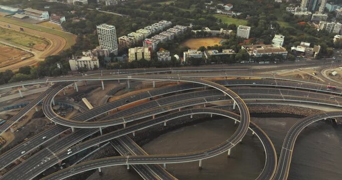 Morning view of the Mumbai Coastal Road in Maharashtra, India, famously known as the 'City of Dreams.' The scene captures a multi-level interchange roadway. A complex road network and urban designs.