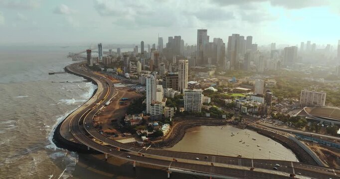 Aerial view of Navi Mumbai International Airport during sunset, showcasing the modern terminal, runways, surrounding waterways, and urban landscape of Navi Mumbai.
