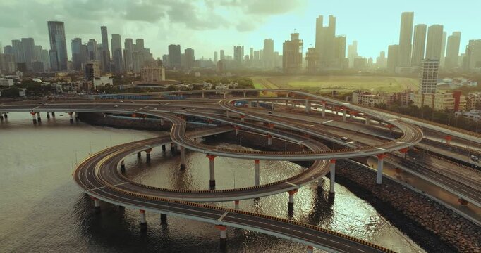 Morning view of the Mumbai Coastal Road in Maharashtra, India, famously known as the 'City of Dreams.' The scene captures a multi-level interchange roadway. A complex road network and urban designs.