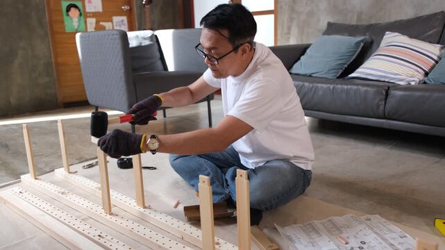 Man furniture assembly living room tool wood floor home project building wooden cabinet shelf near sofa chair