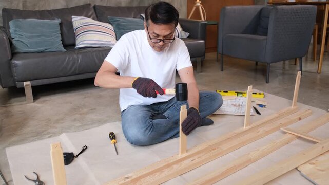 Furniture wood man assembly in living room with tool, focused adult building flat pack shelf frame on floor