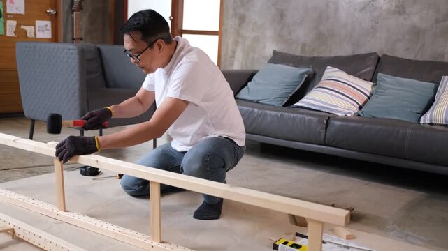 Furniture wood assembly by adult man in living room, tool used for shelving frame, sofa home workshop project