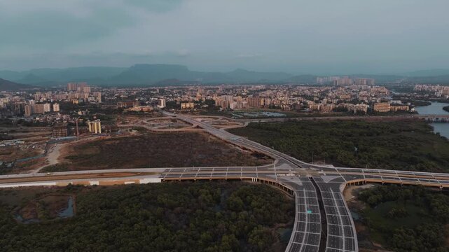 Aerial view of Panvel Road near Navi Mumbai, Maharashtra, showcasing modern roads, elevated infrastructure, green mangrove areas, water bodies, and the expanding urban landscape.