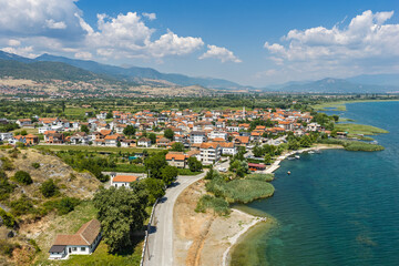 Naklejka premium Aerial drone view of Kalishta village on Lake Ohrid, North Macedonia, with hotel beach, crystal clear lake water, mountain scenery and historic Kalishta Monastery