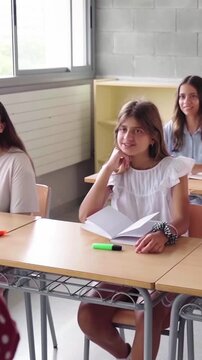 Female teacher talking and teaching to a elementary school students in a classroom. Vertical video with copy space.