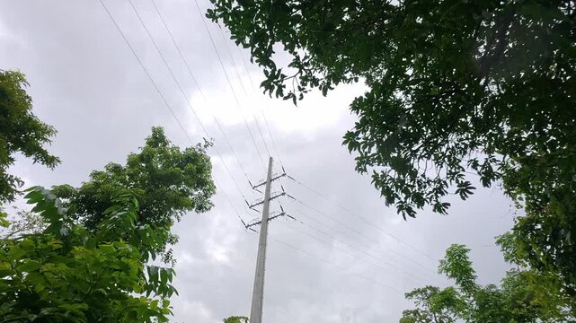High voltage electricity transmission tower seen from a low angle against the sky