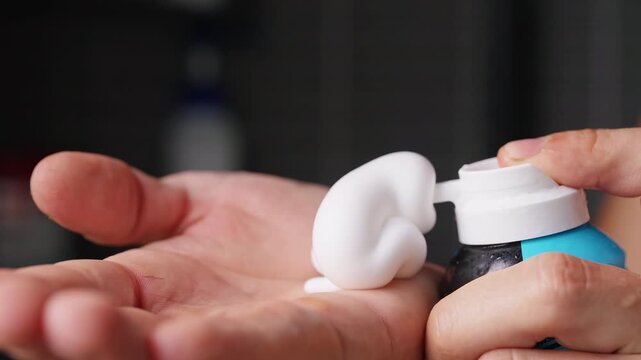 Person Dispenses White Shaving Foam Into Open Palm, Close Up View Supports Personal Grooming and Hygiene