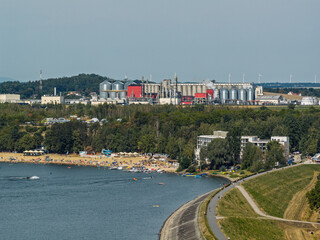 Naklejka premium Aerial drone view of Lake Nysa and Skorochow Beach in Lower Silesia, Poland, with Bioagra factory of bioethanol and ethanol production plant and corn fields visible in the surrounding landscape