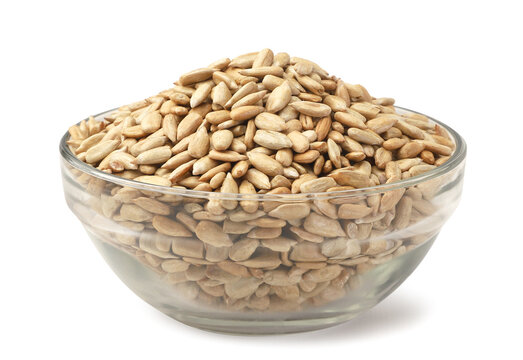 Roasted sunflower seeds in a glass bowl on a white. Isolated