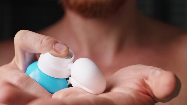 Man Dispenses White Shaving Foam Into Open Palm, Close Up of Bare Chest and Hands Showing Personal Grooming and Hygiene