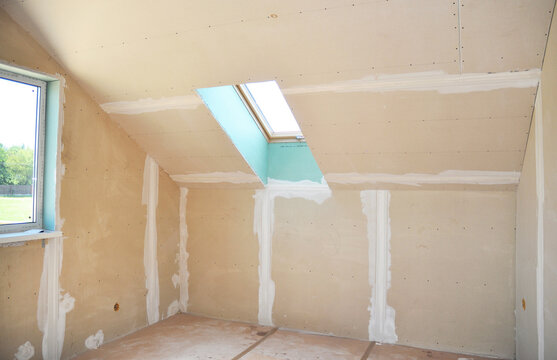Attic renovation repair with skylight and unfinished drywall