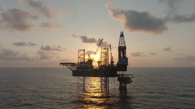 Aerial top view of offshore jack up rig and offshore platform during sunset for oil and gas exploration and production. 