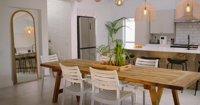 Operator is panning camera right, showing wood table with plants and chairs to reveal kitchen
