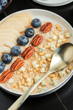 Oatmeal. Bowl of oatmeal porridge with blackberry, bananas and chia seeds on gray concrete old table background. Top view in flat lay style. Natural ingredients. Hot healthy breakfast and diet food