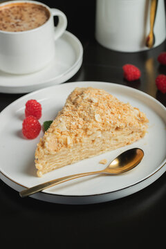Sliced Napoleon cake on a white wooden table. Classic dessert