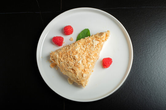 Sliced Napoleon cake on a white wooden table. Classic dessert