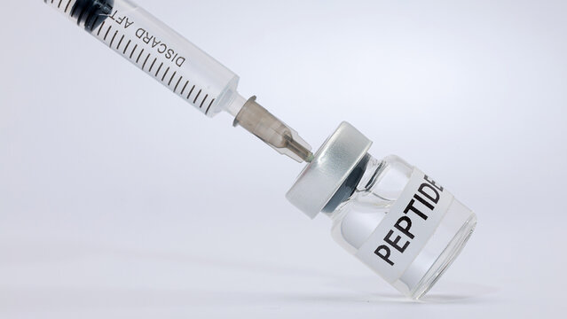 Medical syringe drawing liquid peptide therapy vaccine vial showing serious hopeful clinical treatment concept in studio white background