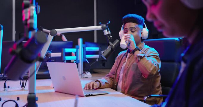 After co-host prompt Diverse co-hosts in studio host adjusting mic speaking sipping coffee smiling