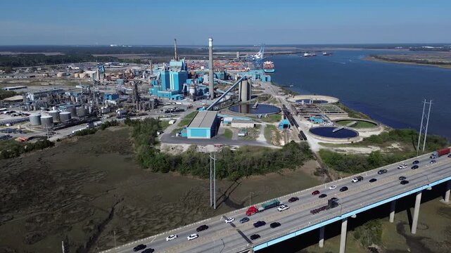 Elevated highway lanes steer Interstate 526 across South Carolina Lowcountry marshes beside Cooper River refineries. Multi lane roadways support coastal commerce, North Charleston