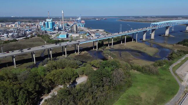 Paved viaduct lanes carry Interstate 526 across South Carolina Lowcountry Cooper River wetlands near Charleston Farms. Flowing vehicular routes link major industrial corridors, North Charleston