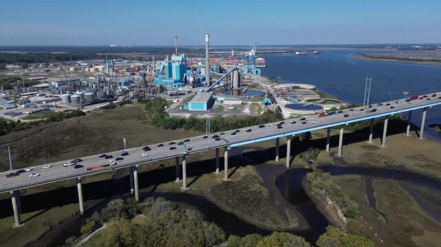 Concrete highway spans carry Interstate 526 across South Carolina Lowcountry wetlands near Cooper River chemical plants. Multi lane expressways link heavy freight routes, North Charleston