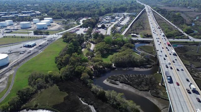 Curving multi lane viaducts steer Interstate 526 across South Carolina Lowcountry wetlands near Lincoln Avenue storage depots. Commuter traffic routes pass tidal creeks, North Charleston