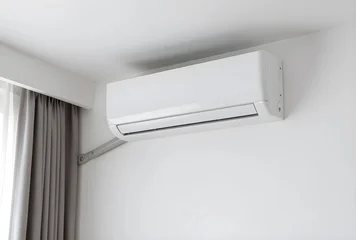 Home cooling and climate control, modern white air conditioner unit installed on a clean wall in a residential room © Pixel-Shot