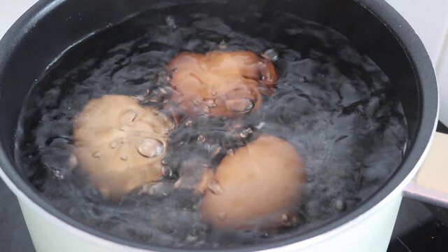 Cooking boiled eggs in hot water inside a cooking pot