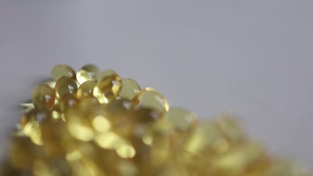 Omega 3 vitamin D and vitamin A golden softgel capsules in macro closeup showing translucent dietary supplements for nutrition wellness healthcare and a healthy lifestyle