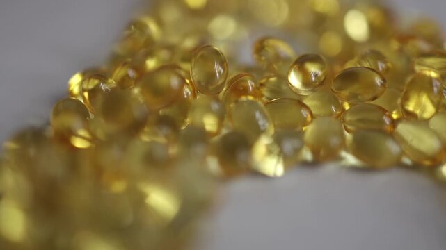 Vitamin A golden softgel capsules arranged in a letter A shape on white background with selective focus representing nutrition supplements wellness and healthy lifestyles