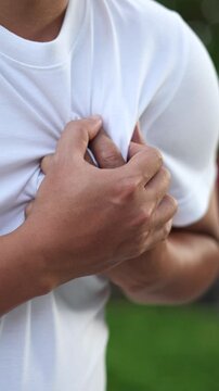 Men have chest pain. hand hold chest with heart attack symptoms, caused by heart disease, leak, dilatation, enlarged coronary heart, press on the chest with a painful expression.
