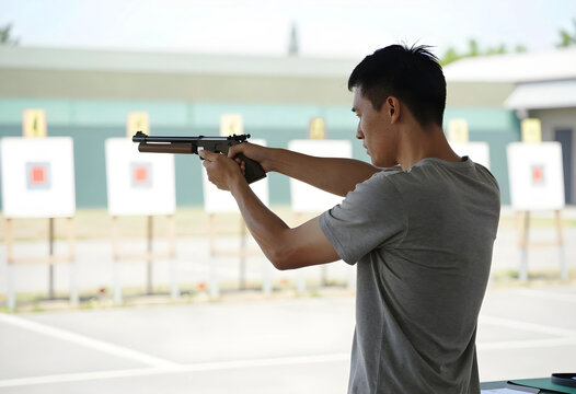 Target shooting practice and marksmanship training, man aiming air pistol at outdoor shooting range for sport and recreation