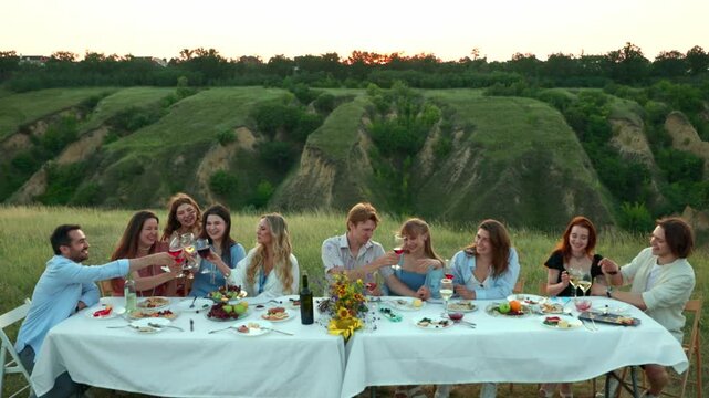 Friends relaxing together after meal in peaceful countryside. Concept of slow living, social wellbeing, nature retreats and lifestyle advertising.