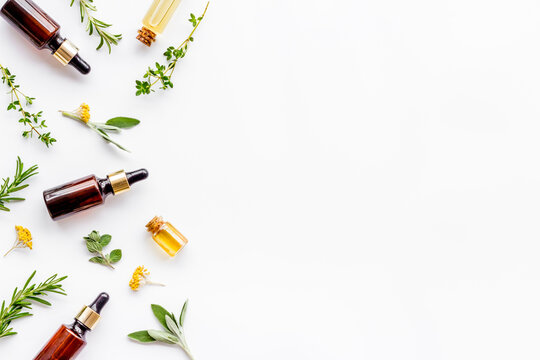 Essential oils and fresh herbs on white background top view pattern frame copy spacee