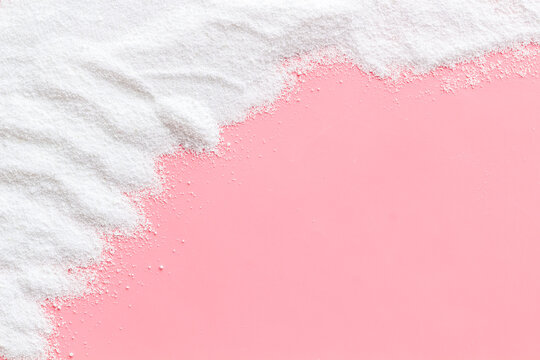 Washing powder scattered on pink background top view frame copy space